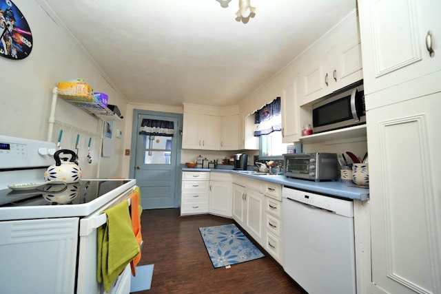 kitchen with dark wood-type flooring, sink, white cabinets, and white appliances