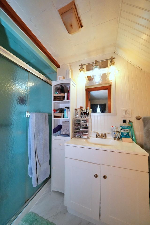 bathroom featuring lofted ceiling, vanity, and a shower with door