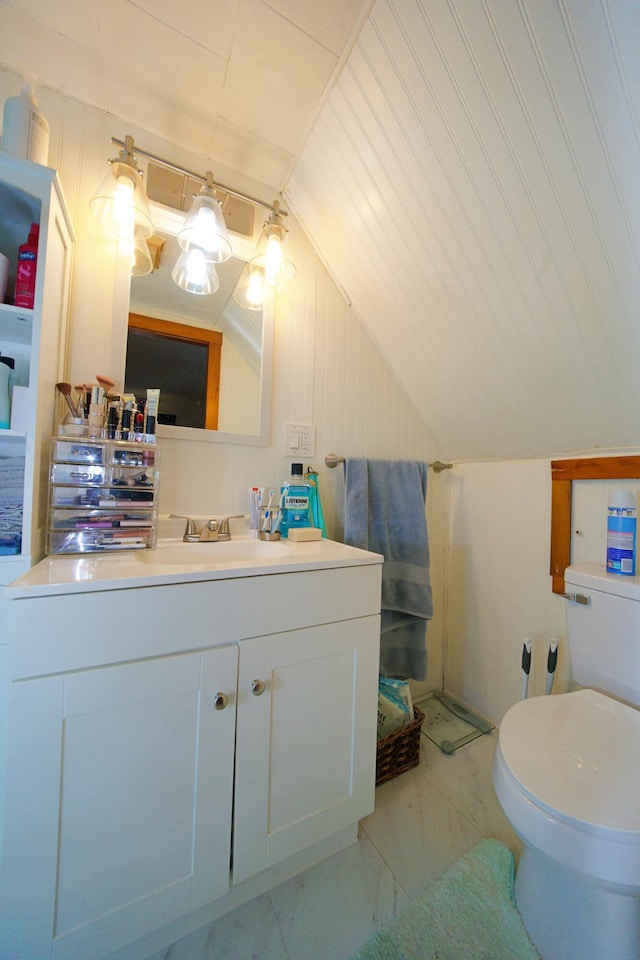 bathroom with vanity, vaulted ceiling, and toilet