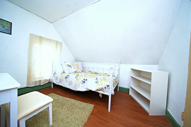 bedroom with dark wood-type flooring and vaulted ceiling