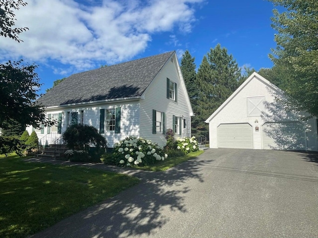 view of side of property with an outbuilding, a garage, and a lawn