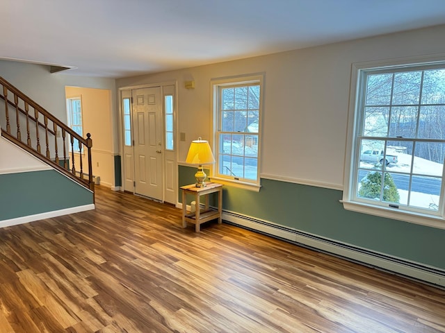 foyer entrance featuring hardwood / wood-style floors and a baseboard heating unit