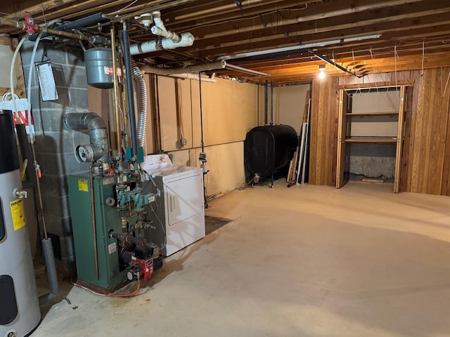 basement featuring electric water heater and washer / dryer