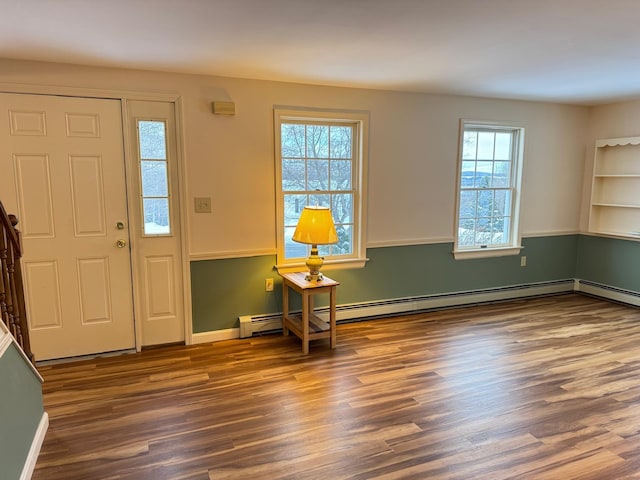 foyer entrance with hardwood / wood-style floors and a baseboard heating unit