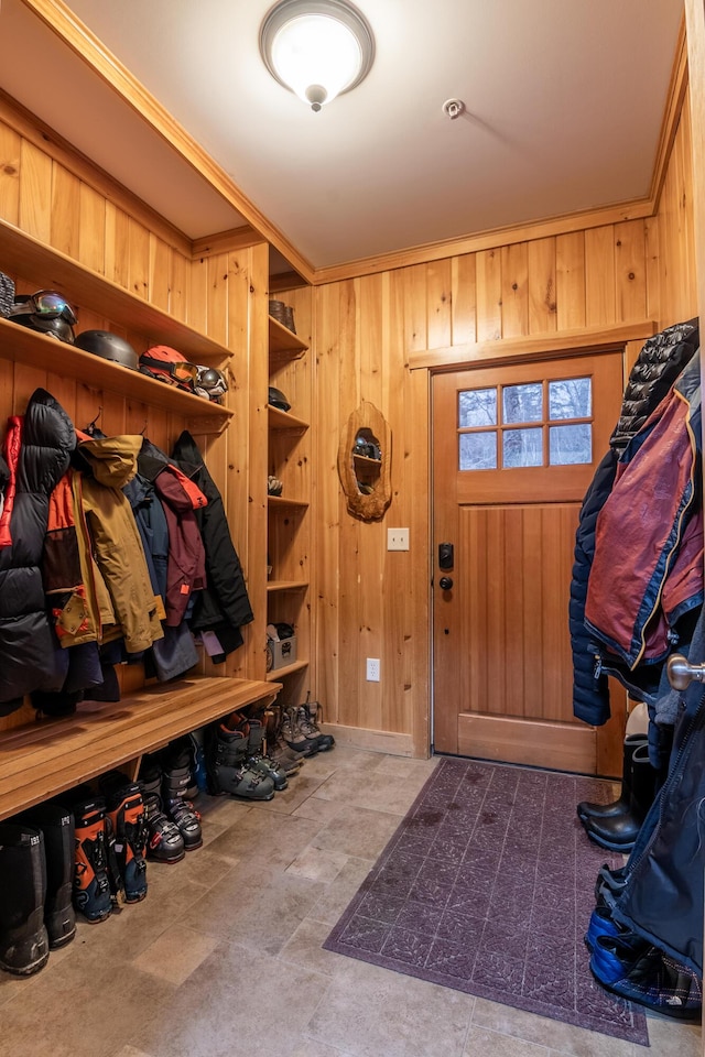 mudroom with crown molding and wooden walls