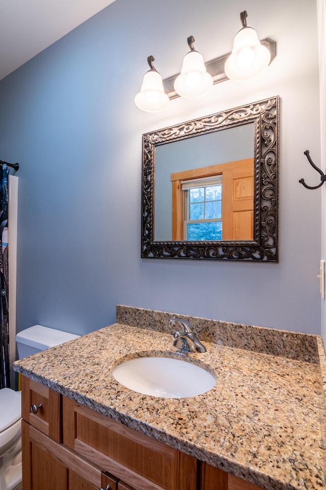 bathroom with vanity, vaulted ceiling, and toilet