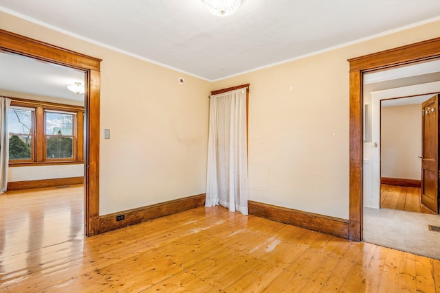 spare room featuring light hardwood / wood-style floors and ornamental molding