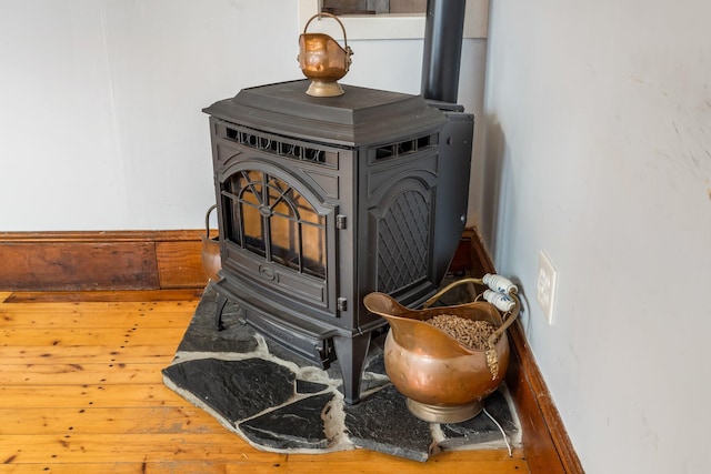 room details with a wood stove and hardwood / wood-style floors