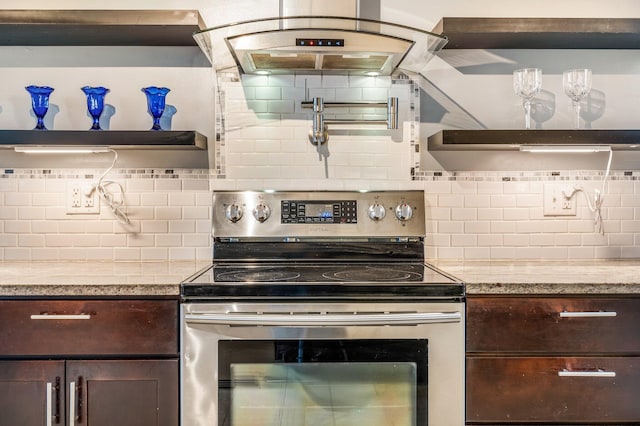 kitchen with light stone countertops, electric range, dark brown cabinets, and tasteful backsplash