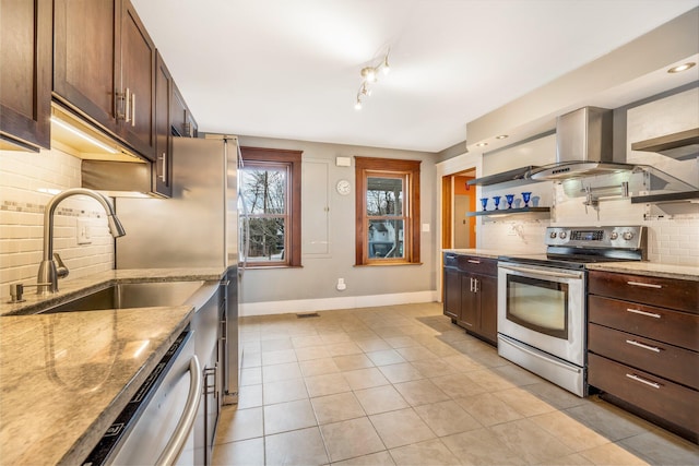 kitchen featuring light tile patterned flooring, light stone countertops, stainless steel appliances, and tasteful backsplash