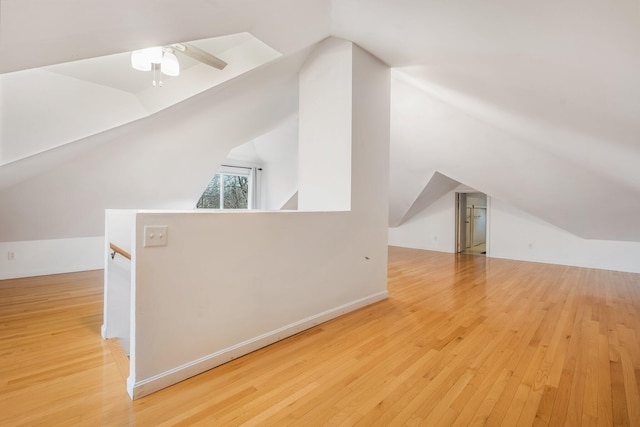 bonus room featuring light wood-type flooring and vaulted ceiling