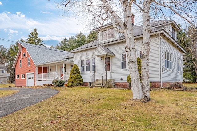 view of front of home featuring a garage, a front lawn, and a porch