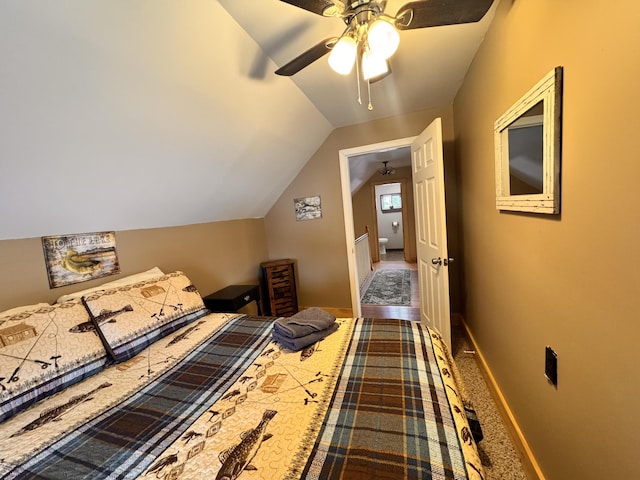 carpeted bedroom with ceiling fan and vaulted ceiling