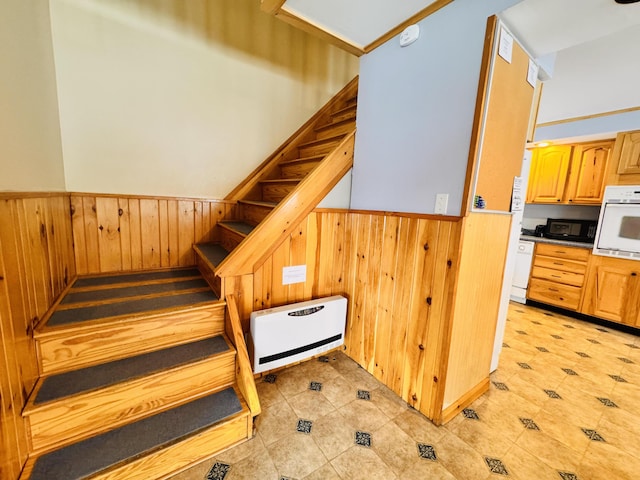 staircase featuring wood walls