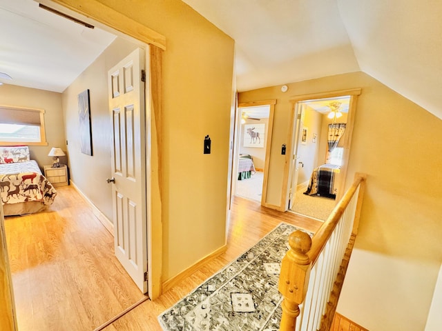 hall featuring lofted ceiling and hardwood / wood-style flooring