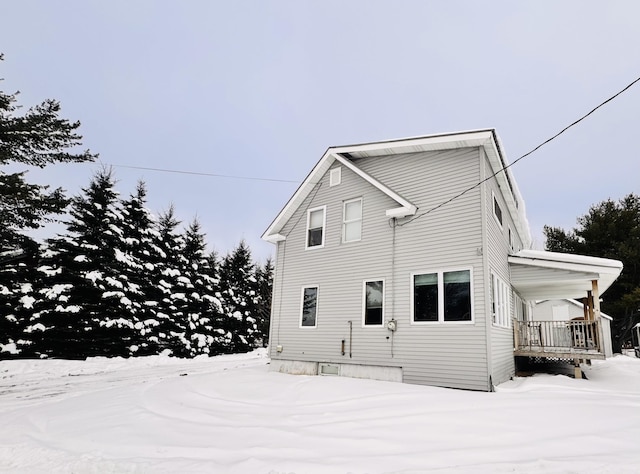 view of snow covered back of property