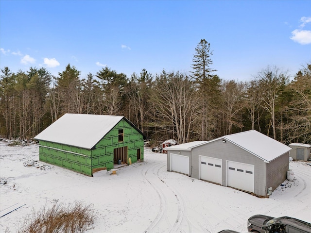 snow covered structure with a garage