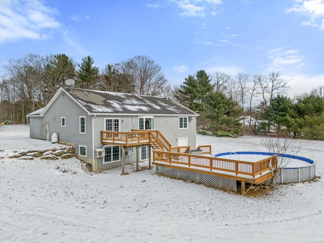 snow covered back of property with a deck