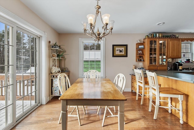 dining space with light hardwood / wood-style flooring and a chandelier