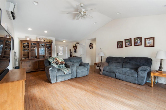 living room featuring hardwood / wood-style flooring, vaulted ceiling, ceiling fan, and an AC wall unit