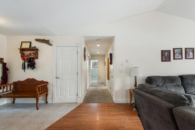 hallway featuring light tile patterned floors and lofted ceiling