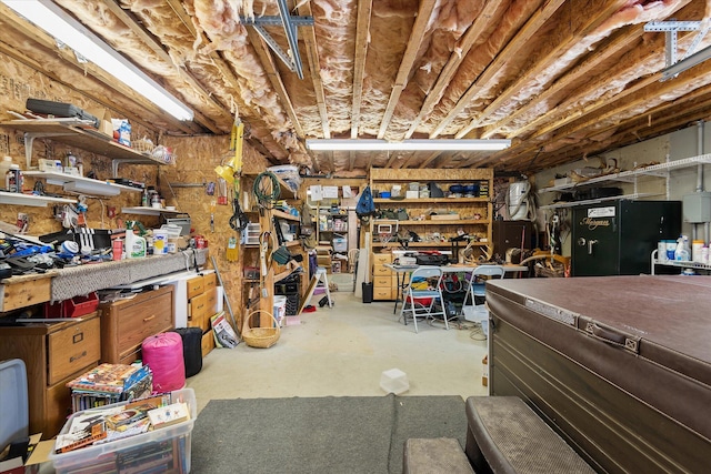 basement with black refrigerator and a workshop area