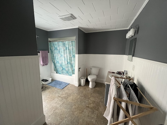 full bathroom with sink, shower / bath combination with curtain, crown molding, and toilet