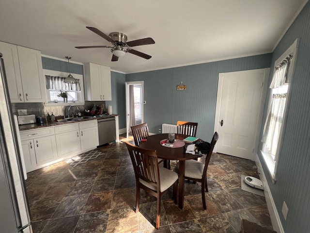 dining area featuring sink, ceiling fan, and ornamental molding