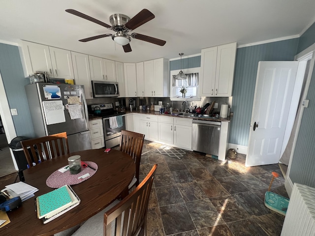 kitchen featuring appliances with stainless steel finishes, ceiling fan, pendant lighting, white cabinets, and sink