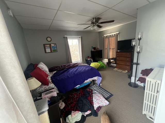 carpeted bedroom featuring a paneled ceiling and ceiling fan