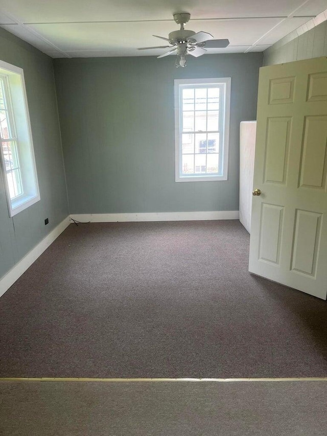 carpeted spare room with ceiling fan