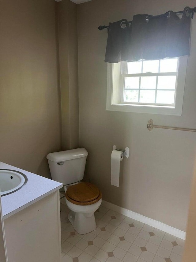 bathroom with toilet, tile patterned floors, and vanity