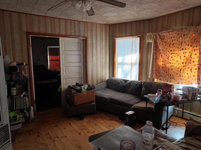 living room with wood-type flooring, a baseboard radiator, and ceiling fan