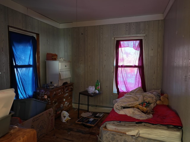 bedroom with baseboard heating and wood walls