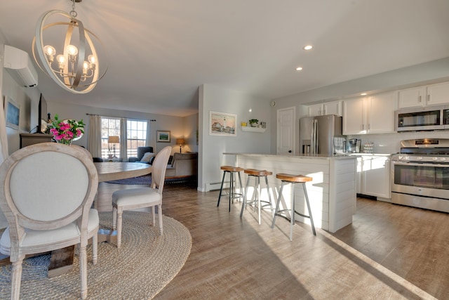 dining room featuring a chandelier, light hardwood / wood-style flooring, a baseboard heating unit, and a wall unit AC