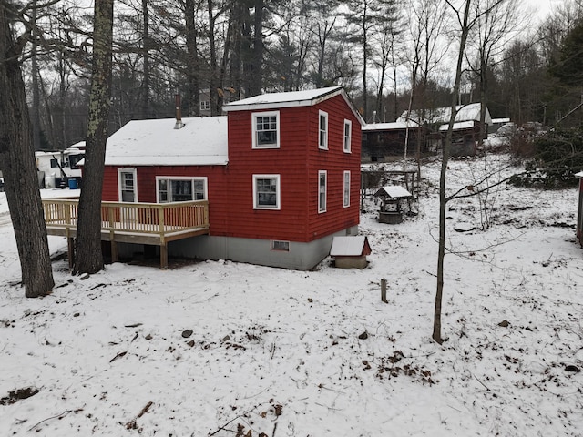 snow covered house with a wooden deck