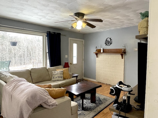 living room with ceiling fan, hardwood / wood-style floors, and a textured ceiling