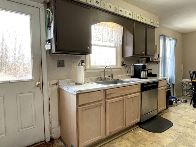 kitchen with sink, stainless steel dishwasher, and light brown cabinets