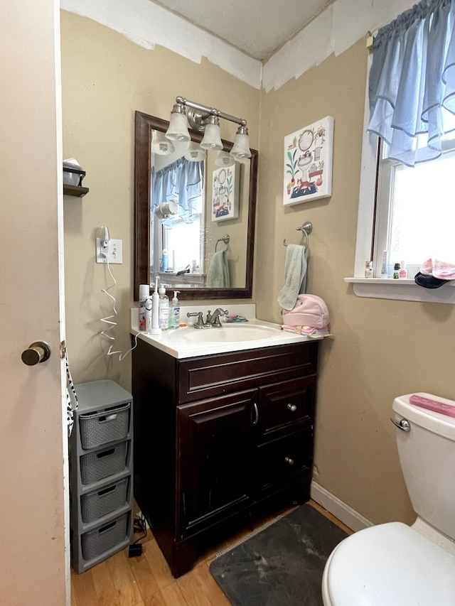 bathroom with hardwood / wood-style flooring, vanity, and toilet