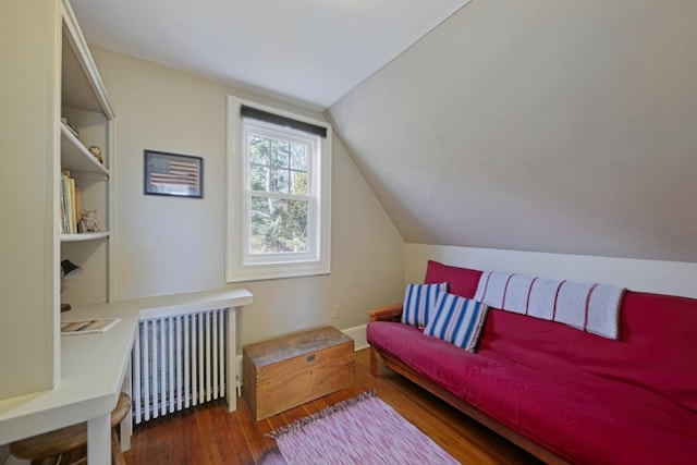 interior space with dark hardwood / wood-style floors, radiator, and lofted ceiling