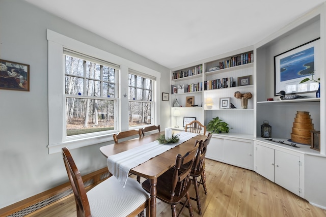 dining space featuring built in shelves and light hardwood / wood-style flooring