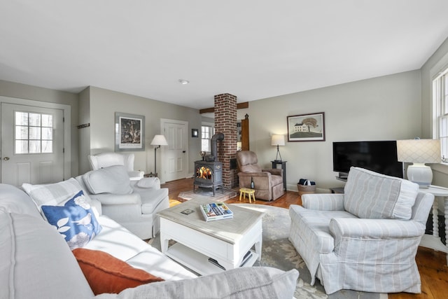 living room with a wood stove and wood-type flooring