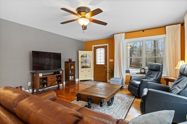 living room with ceiling fan and light hardwood / wood-style flooring