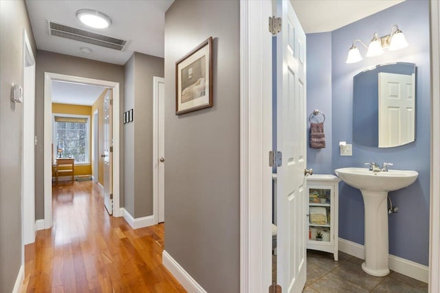 corridor with sink and hardwood / wood-style floors