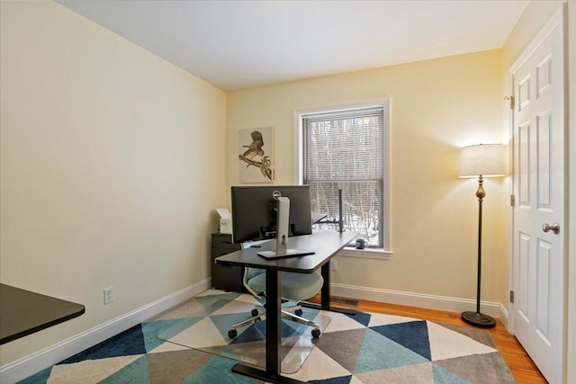 office with light hardwood / wood-style flooring and a wealth of natural light