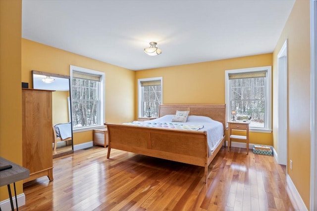 bedroom with a baseboard heating unit and hardwood / wood-style flooring