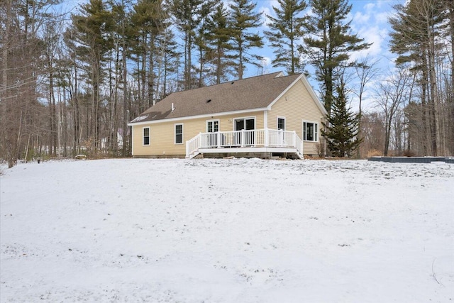 snow covered house with a wooden deck