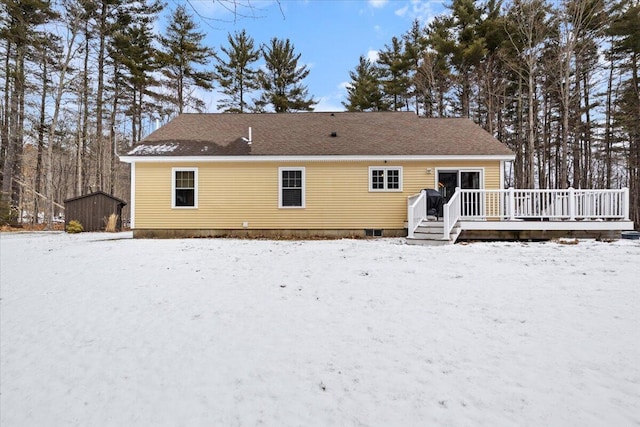 snow covered back of property featuring a wooden deck