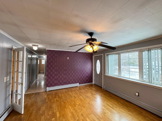 unfurnished room with a baseboard heating unit, ornamental molding, and light hardwood / wood-style floors