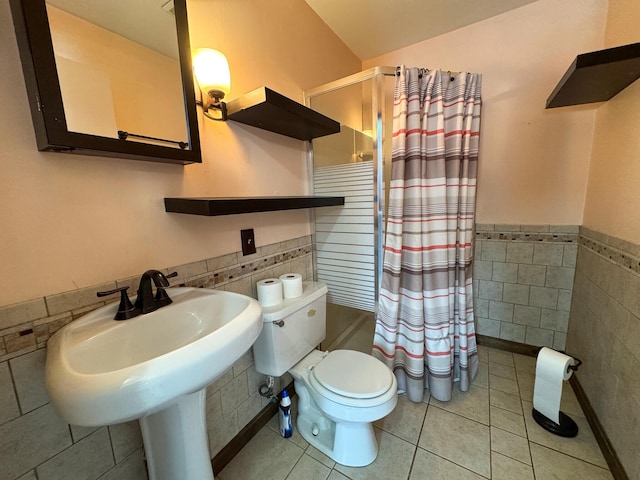 full bathroom featuring tile patterned flooring, shower / bath combination with curtain, toilet, tile walls, and sink